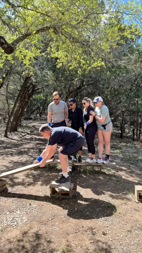 Corporate team balancing on low ropes element at Cielo Vista Team Challenge.